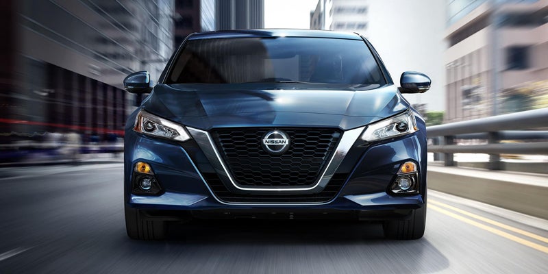 Front view of a black Nissan Altima driving on a city road