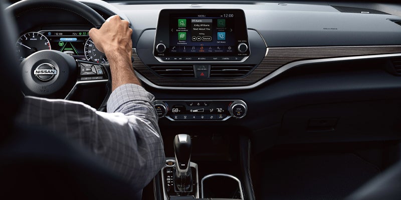 Driver's hands on a Nissan steering wheel