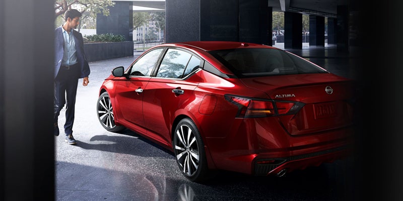 High-angle shot of a metallic red sedan, seen from the rear