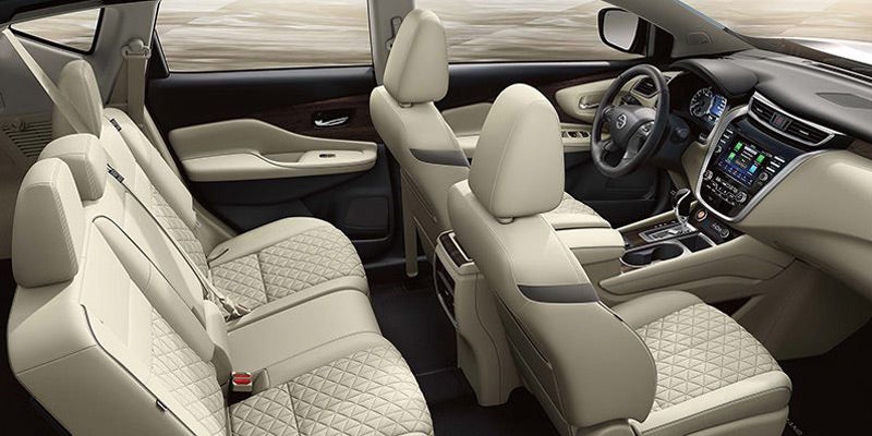 Interior of a premium car with tan leather seats, tan dashboard, and dark trim.