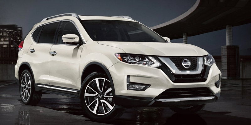 White Nissan Rogue SUV parked outdoors at night
