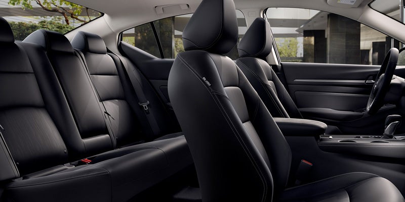 Interior view of a car with dark grey or black leather seats and a glimpse of the steering wheel.