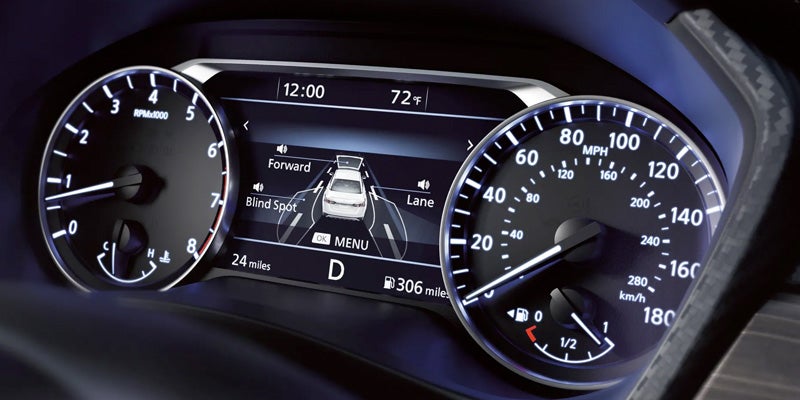 A car's dashboard displaying analog RPM and speedometer