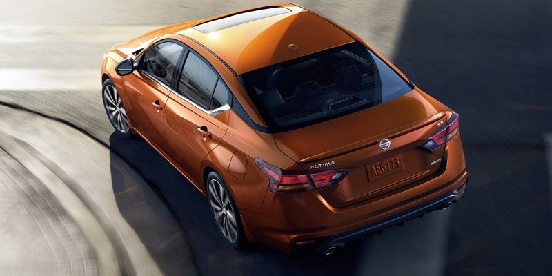 Elevated rear view of a shiny orange Nissan Altima sedan