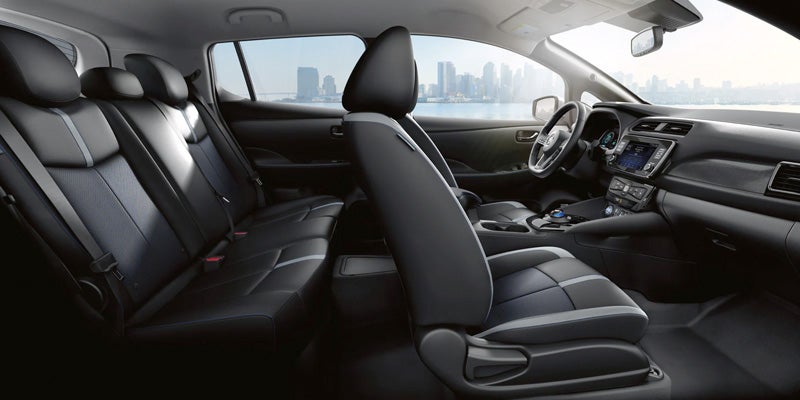 Interior view of a car with dark grey and light grey seats, dashboard