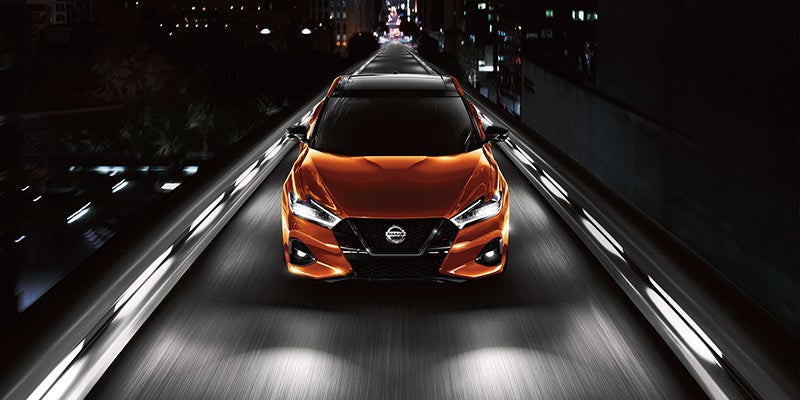 Front view of a sleek, dark orange Nissan Maxima