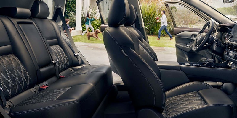 Interior view of a car with black leather seats, a steering wheel