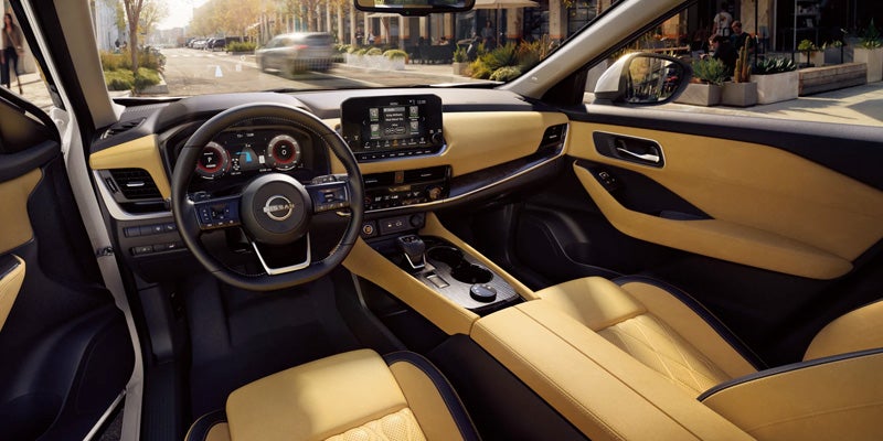 Interior of a car with two-toned tan and black seating, dashboard