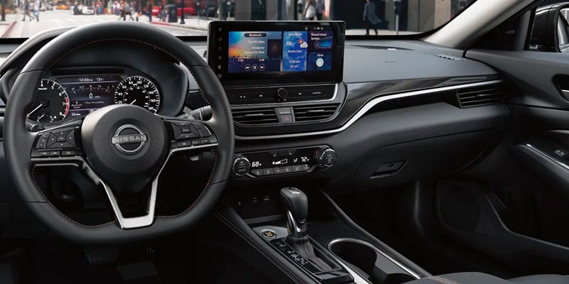 Interior view of a modern car dashboard with a steering wheel, digital instrument cluster, and large infotainment screen.
