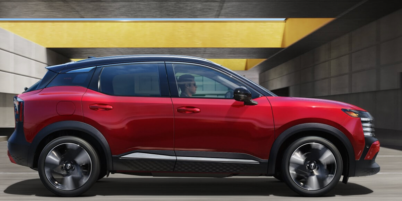 Red Chevrolet Equinox driving through a modern underpass.
